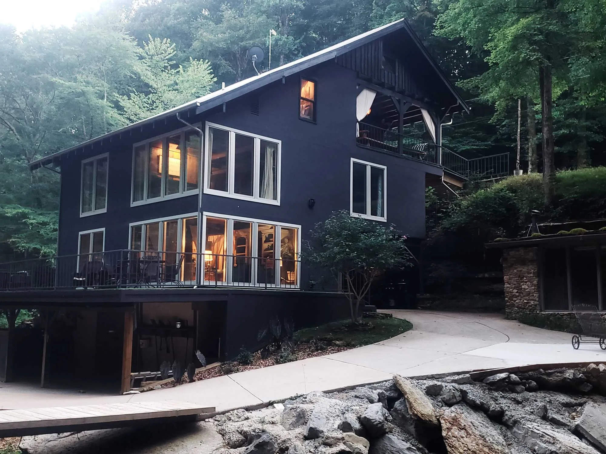 The Waterfall House lit at night among the trees